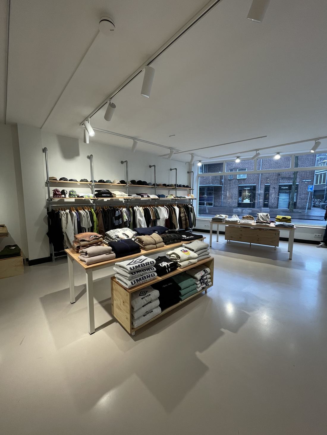 Tafels met truien en caps in de winkel